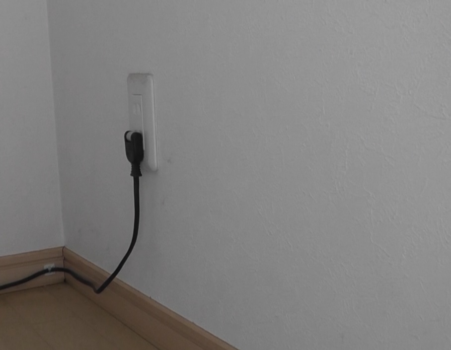 屋外水道の壁裏にある室内の電源コンセントから送り穴を使用して屋外へ電源ケーブルを分岐させる