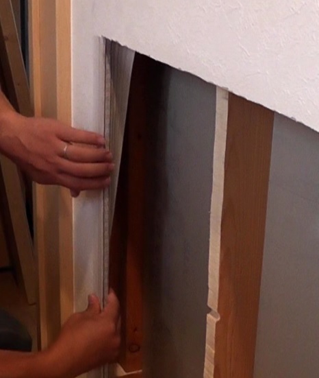 本棚を壁内に埋め込むために石膏ボードに開けた穴の端面に壁紙を巻き付けて化粧し、白い粉が出てくるのを防止する