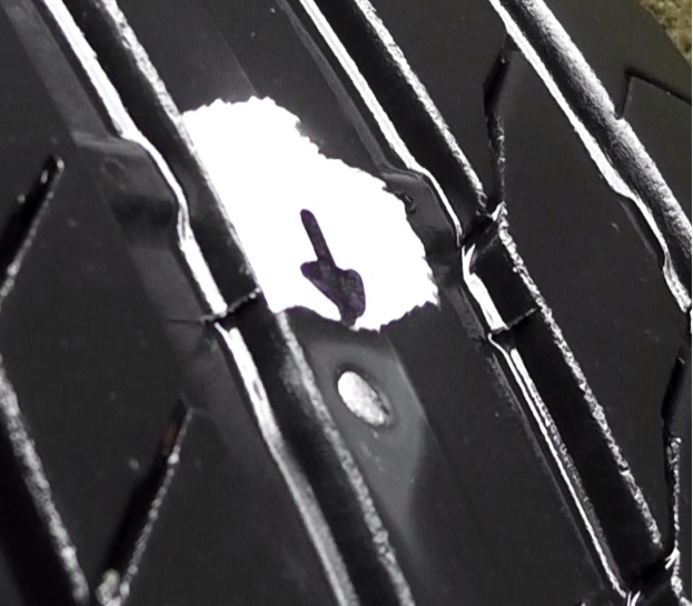 釘が刺さってパンクしたタイヤの空気漏れ箇所をマーキングして明確にする