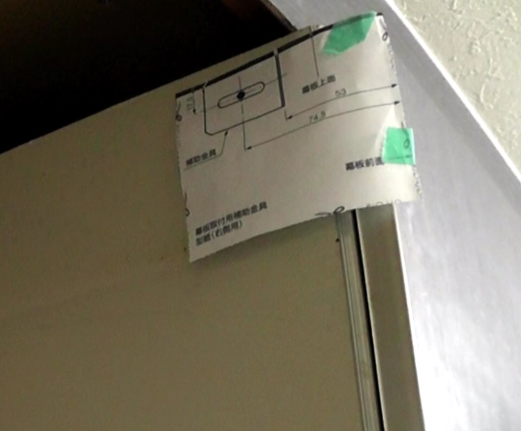 シロッコファン式レンジフードの幕板固定金具のネジ穴を型紙を貼り付けて下穴を開ける
