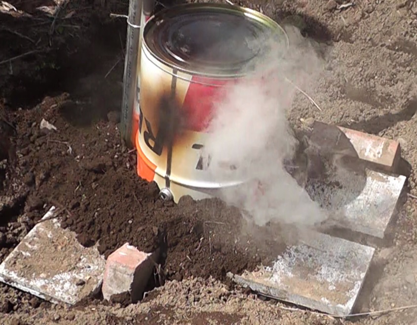 竹炭にするペール缶の中の竹に着火したらブロックの間にレンガを嵌め土で少し埋める